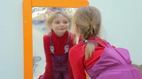 Girl looking at herself in a distorting mirror Stock Footage 44751673