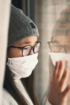 Girl looking at infinity reflected in the window with mask Stock-Fotos