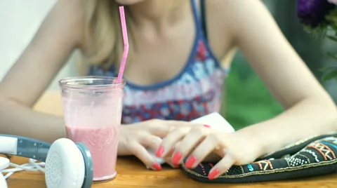 Girl looking irritated while checking time on smartphone in the outdoor cafe Stock Footage