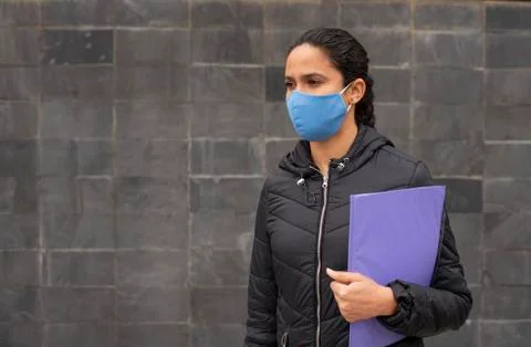 Girl looking for a job with blue medical mask in the street Stock Photos