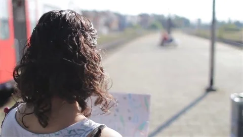 Girl looking at a map and looking at a train leaving from a train station Stock Footage 69254191