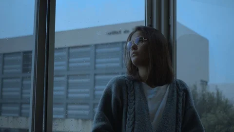 Girl looking out the window while raining Video stock 128678939