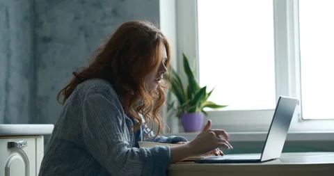 Girl Looking at screen, talking, pressing keys during online learning Stock Footage 334417716