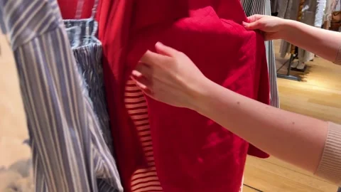A girl looking at some models of clothes to choose what she likes.  Stock Footage 311934836