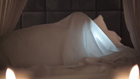 Girl looking up something under the covers Stock Footage 259851148