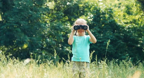 Girl looking through binoculars at camera and waving hand Video stock 51622074