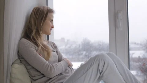 Girl looking through out the window on snowfall Stock Footage 86301715