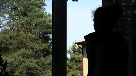 Girl looking through the window Stock Footage 41679995