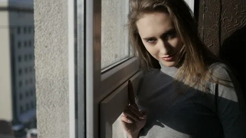 Girl is looking through the window Stock Footage 86589170