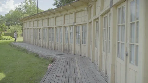 Girl looking through a window into old sanatorium building, Krimulda, Latvia 4k Stock Footage 94255548