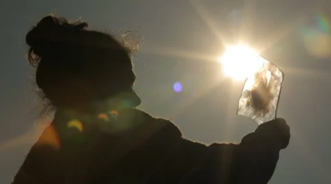 Girl looks at the beginning of the solar eclipse through special glass. Stock Footage 62111828
