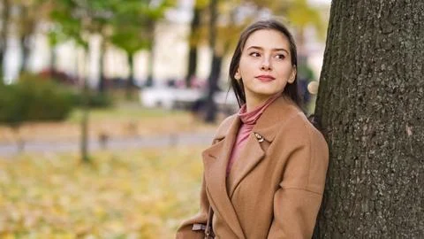 Girl looks into the distance standing by a tree Stock Photos