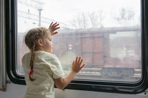 The girl looks into the distance from the window of a train car Stock Photos