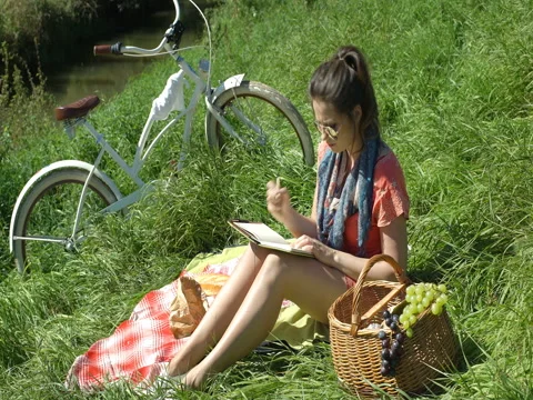 Girl looks irritated while writing in her diary, steadycam shot Stock Footage