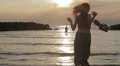 girl in love runs to her boyfriend into the sea - hugs and kisses - sunset HD Footage