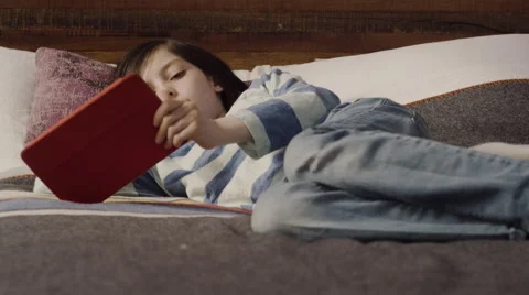Girl lying on bed and using digital tablet in bedroom Stock Footage 63861218