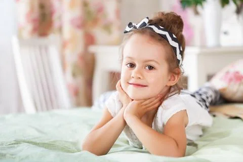 Girl is lying on the bed Stock Photos