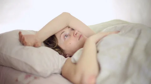 Girl lying in bed, she is joined by her husband Stock Footage 61061864