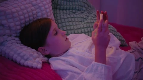 Girl Lying in Bed Using Smartphone at Night Stock Footage 345528212
