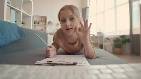 Girl Lying on Couch while Studying via Internet Stock Footage 137175497