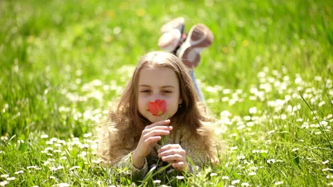 Girl lying on grass, grassplot on background. Tulip fragrance concept. Girl on Stock Footage 108011700