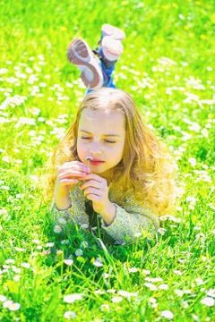 Girl lying on grass, grassplot on background. Sensitivity concept. Child enjoy Stock Photos
