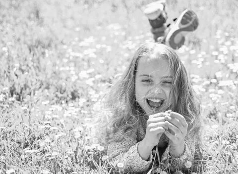 Girl lying on grass, grassplot on background. Child enjoy spring sunny weather Stock Photos