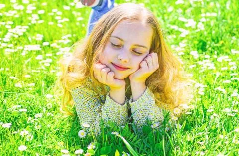 Girl lying on grass at grassplot, green background. Girl on dreamy face spend Stock Photos