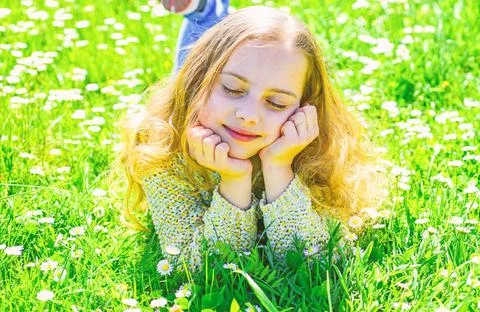Girl lying on grass at grassplot, green background. Girl on dreamy face spend Stock Photos