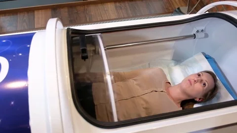 Girl lying in the hyperbaric chamber with an open glass cover Stock Footage 84113487