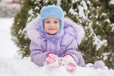Girl lying in the snow and the snow smiling Stock-Fotos