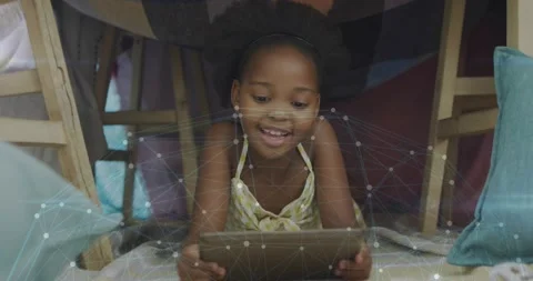 Girl lying under fort tapping tablet and causing network graphic expanding for Stock Footage 333833517
