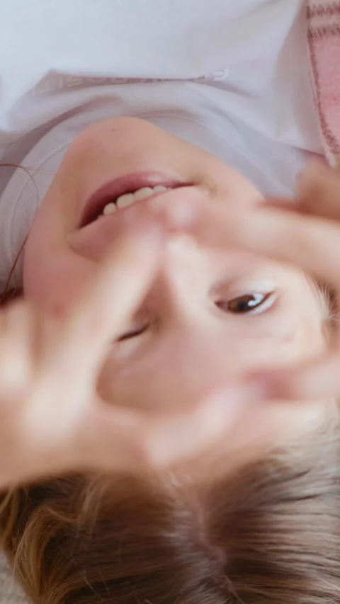 Girl lying upside down making heart with fingers Stock Footage 313048582
