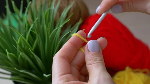 The girl makes the first knots crocheted yellow color. Handmade crochet close-up Stock Footage 107564458