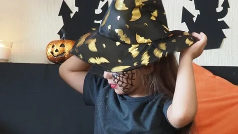 The girl makes funny faces, plays with a cloak for halloween trick or treat Stock Footage 163905009