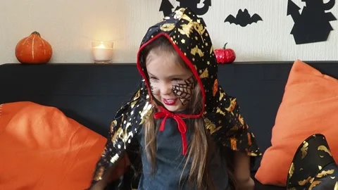 The girl makes funny faces, plays with a cloak for halloween trick or treat 库存影片 163908809
