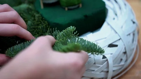 Girl makes handcrafted christmas composition with fir-tree branches, close-up Stock Footage 85282653