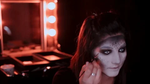 Girl makes a make-up in the style of a witch Halloween Stock Footage 69206443