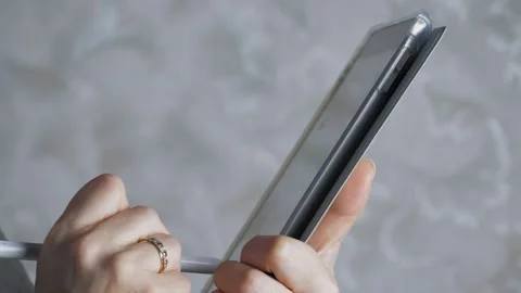 The girl makes a note on the tablet with a stylus. Close-up female hands hold a Stock Footage 222475731