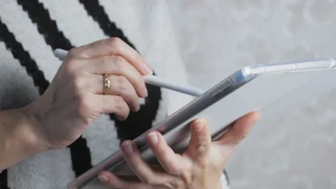 The girl makes a note on the tablet with a stylus. Close-up female hands hold a Video stock 222815629