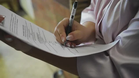 The girl makes notes with a ballpoint pen on a sheet with text. Shot close-up Stock Footage 139785779