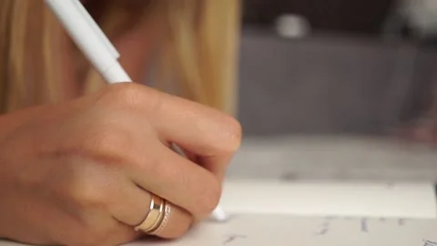 Girl makes notes in a notebook. Hand writes. Girl doing her homework. Remote Stock Footage 135657359