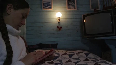 Girl makes notes in a notebook sitting in the room with the light of the lamp Stock Footage 72152548