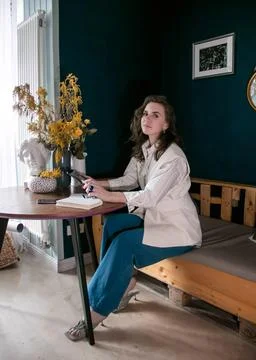The girl makes notes in a notebook at the table Stock Photos