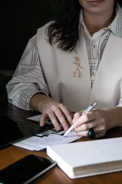 The girl makes notes in a notebook at the table Stock Photos