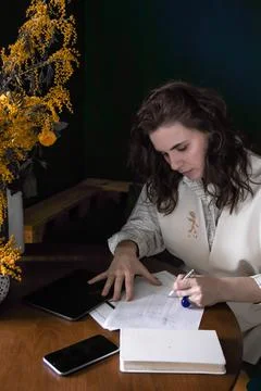 The girl makes notes in a notebook at the table Stock Photos