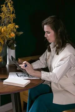 The girl makes notes in a notebook at the table 스톡 사진