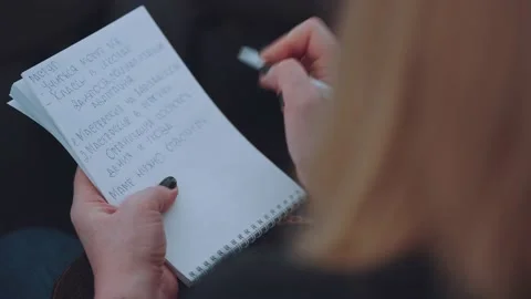The girl makes notes in a notebook, write in a notebook at a conference Stock Footage 235893364