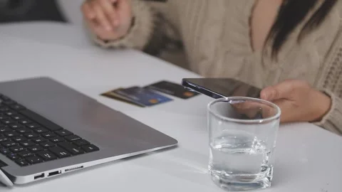 Girl makes a purchase on the Internet on the computer with credit card Stock Footage 313583815