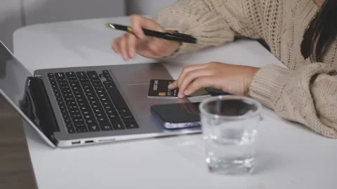 Girl makes a purchase on the Internet on the computer with credit card Stock Footage 313583816
